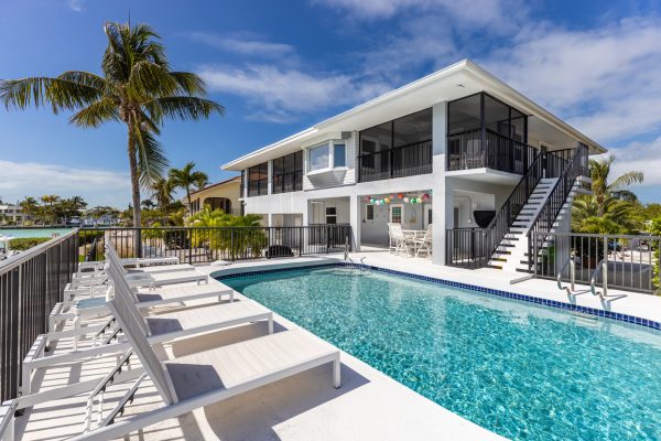 modern-building-with-swimming-pool-trees-chairs-landscape-with-blue-sky-scenic-enviroment